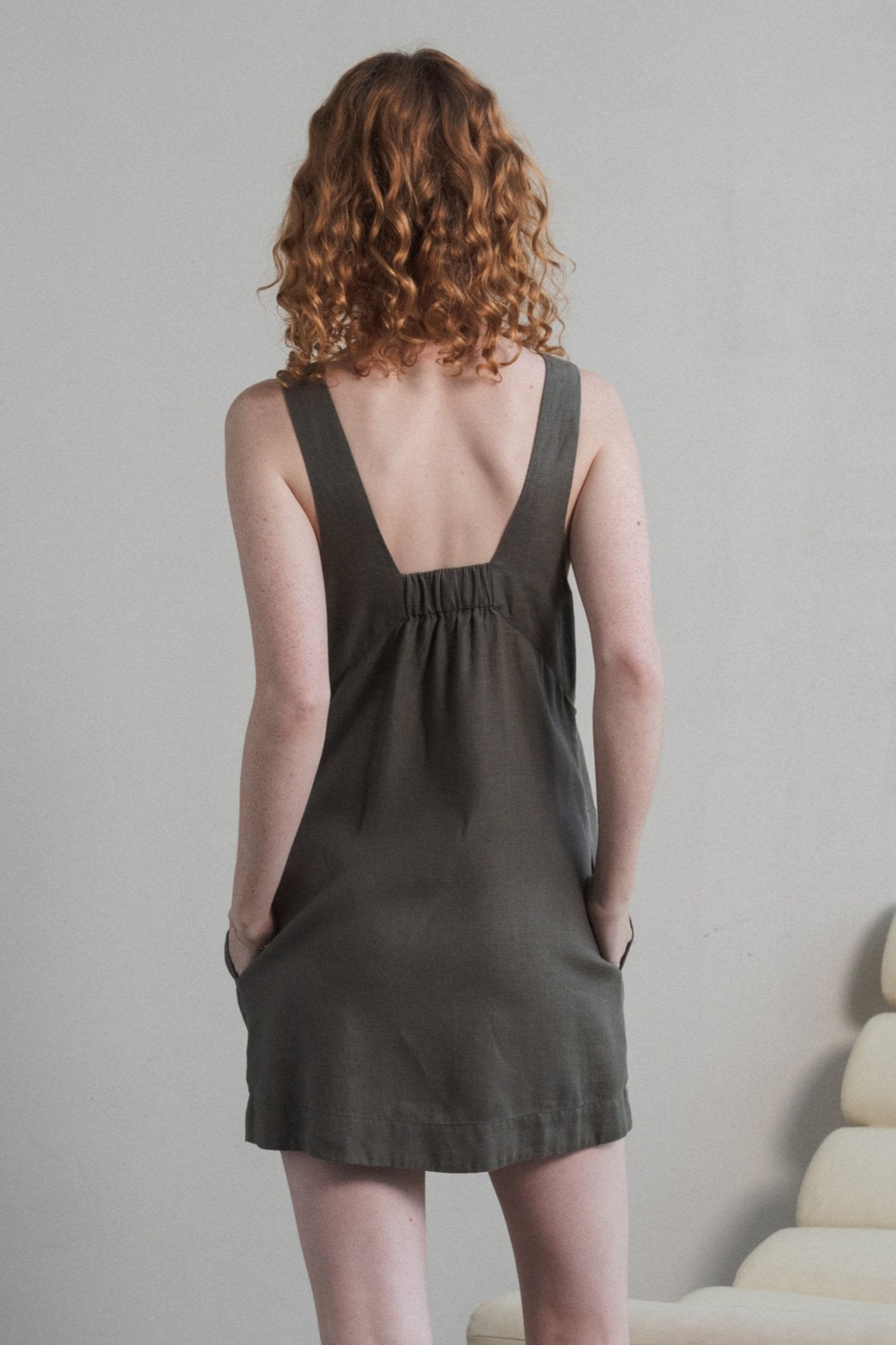 LILLY PILLY woman showing back view while wearing a Isla linen dress in Khaki with a neutral background