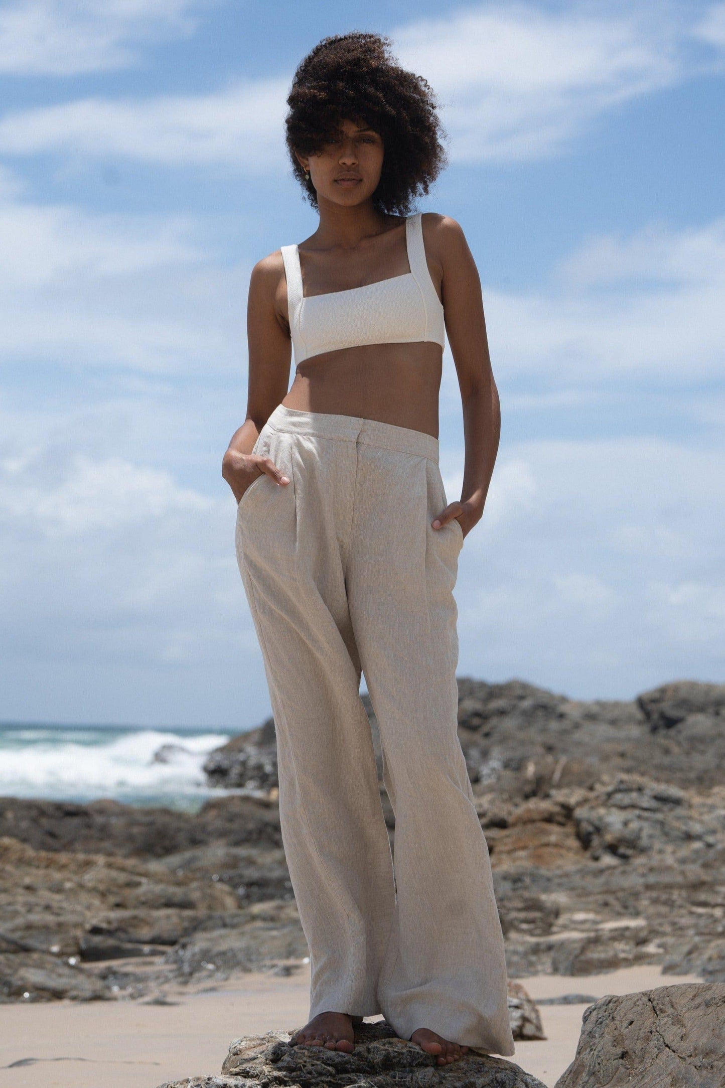 LILLY PILLY Oli linen pants in Oatmeal standing on a rock