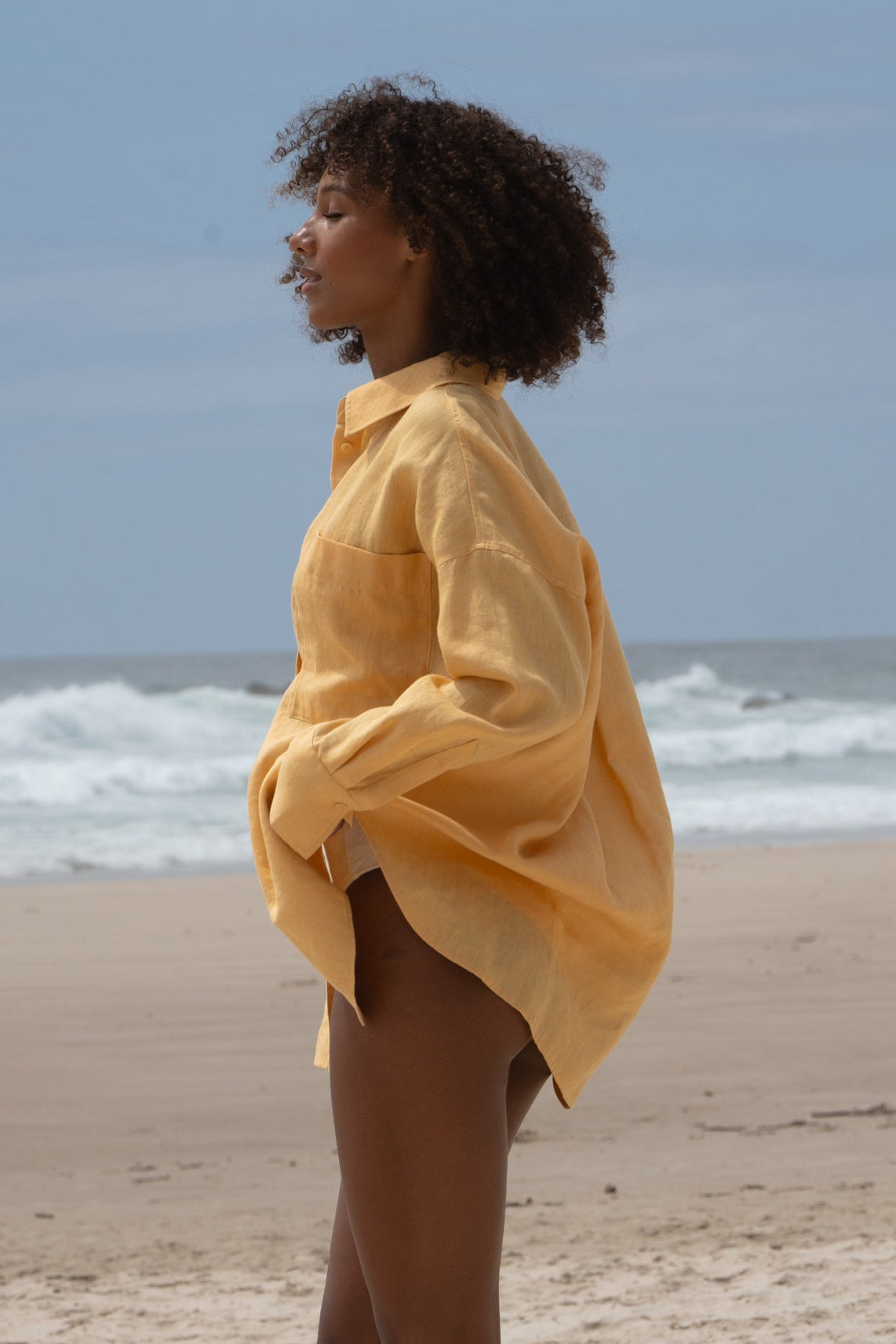 Lilly Pilly Collection Kirra shirt made from European linen in Butter side view on the beach