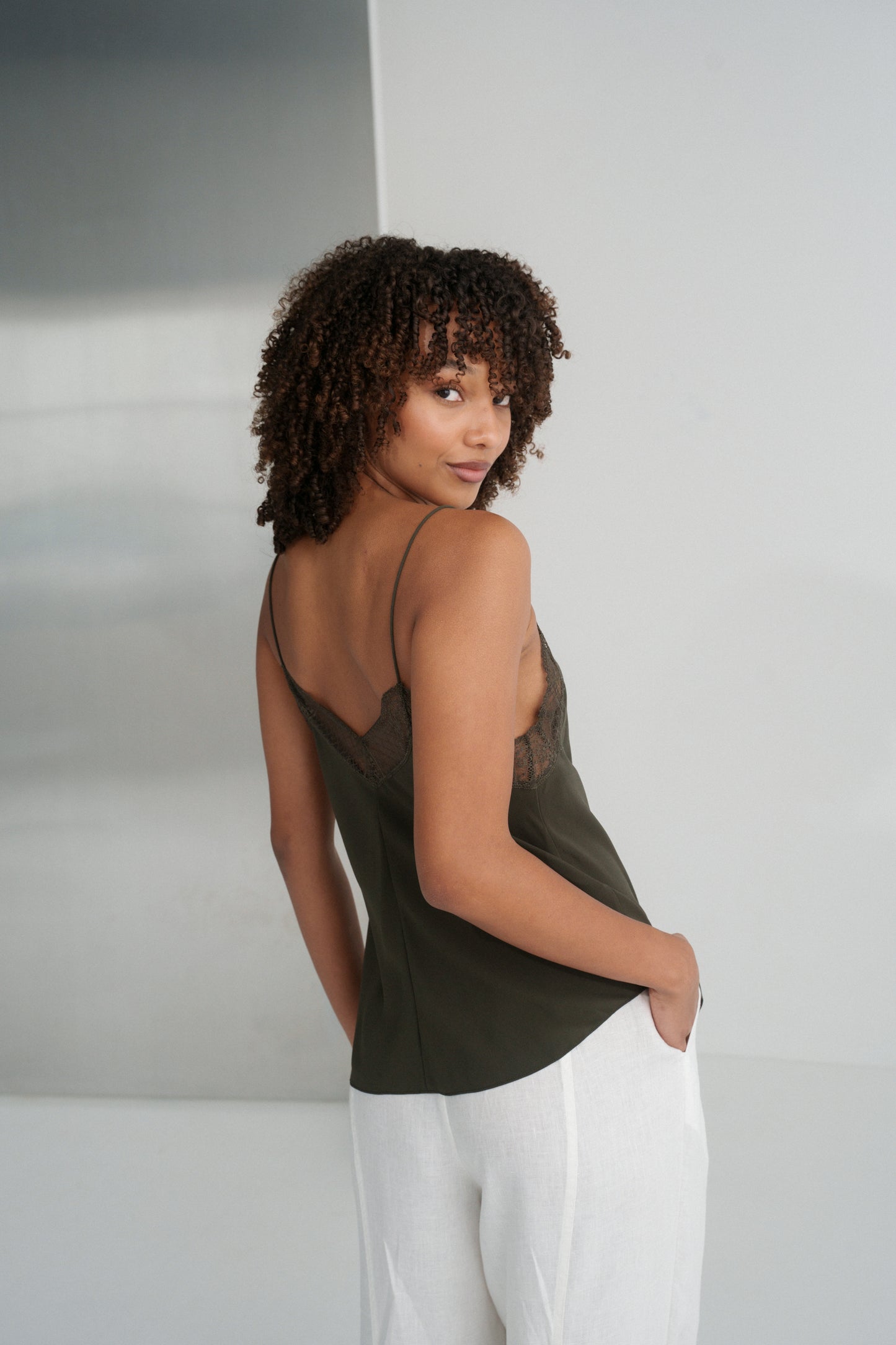 LILLY PILLY woman wearing Frankie silk cami in khaki  and ivory Oli linen pants