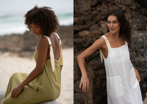 LILLY PILLY women wearing Remi linen dress in Olive and Ivory while standing on a beach in front of the rocks
