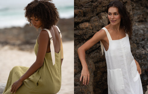 LILLY PILLY women wearing Remi linen dress in Olive and Ivory while standing on a beach in front of the rocks